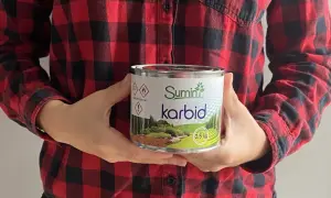 Osoba w koszuli w kratę trzyma puszkę z napisem "Sumin karbid". Szukasz gdzie kupić karbid?