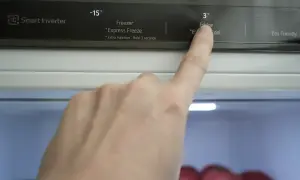 Palec naciska przycisk "Fridge" na panelu sterowania lodówki Amica No Frost, ustawiając temperaturę na 3°C.
