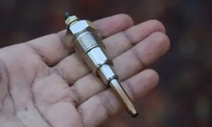 Metalowa świeca żarowa w dłoni, kluczowy element do sprawdzenia, jak sprawdzić świece żarowe w dieslu.