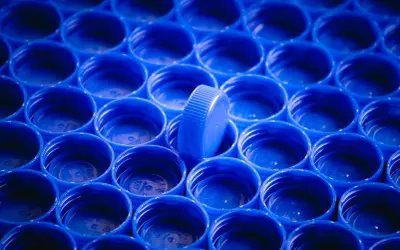 Rząd niebieskich nakrętek, jedna wyróżnia się. Zastanawiasz się, czym odtłuścić plastik?
