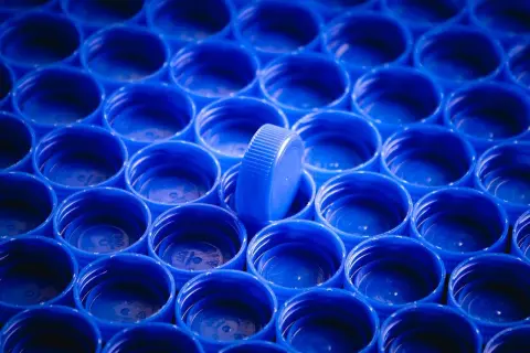 Rząd niebieskich nakrętek, jedna wyróżnia się. Zastanawiasz się, czym odtłuścić plastik?
