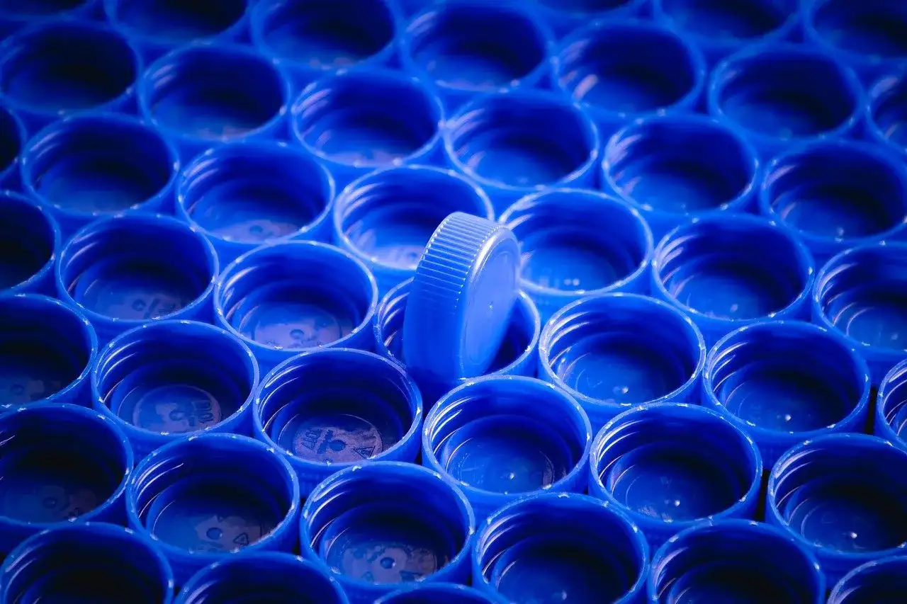Rząd niebieskich nakrętek, jedna wyróżnia się. Zastanawiasz się, czym odtłuścić plastik?