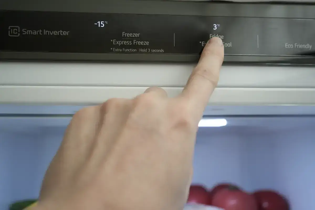 Palec dotyka panelu sterowania lodówki, pokazując jak ustawić lodówkę Amica No Frost na 3°C.